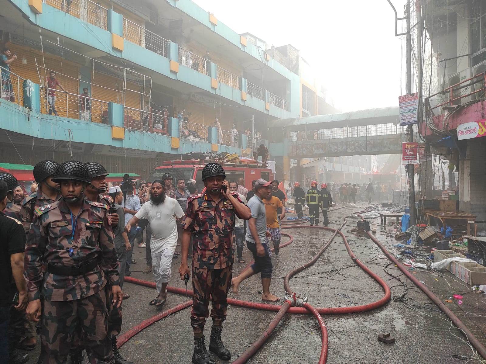 বাধা উপেক্ষা করে দোকান থেকে মালামাল বের করার চেষ্টা করছেন ব্যবসায়ীরা