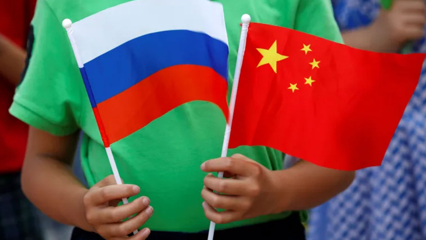 A child holds the national flags of Russia and China in Beijing, China