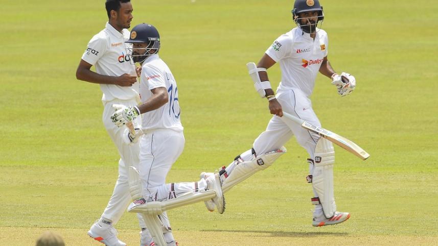 Sri Lanka's Dimuth Karunaratne (C) and Lahiru Thirimanne take a run (1).jpg
