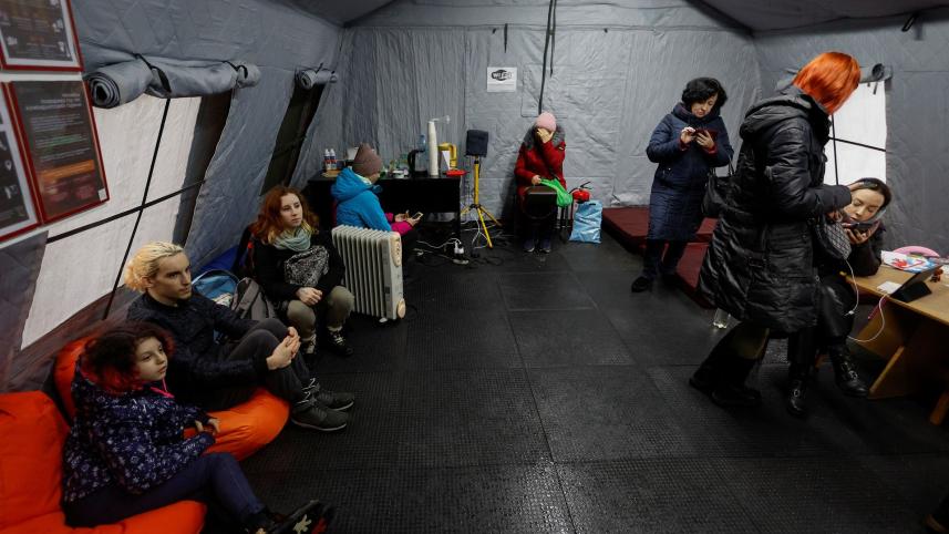 বিদ্যুৎ সরবরাহ বিপর্যস্ত হোয়ার পর একটি আশ্রয়কেন্দ্রে মোবাইল ফোন ও অন্যান্য ডিভাইস চার্জ করছেন এবং ইন্টারনেট ব্যবহার করছেন কিয়েভের বাসিন্দারা। ছবি: রয়টার্স