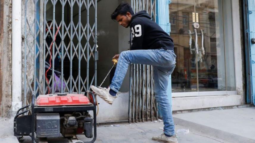 দেশব্যাপি বিদ্যুৎ বিভ্রাটে করাচির এক দোকানি জেনারেটর চালুর চেষ্টা চালাচ্ছেন। ছবি: রয়টার্স