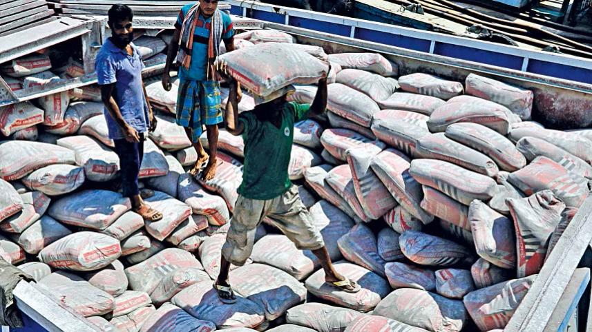 সিমেন্টের বস্তা বহন করছেন শ্রমিকরা। ফাইল ছবি: স্টার