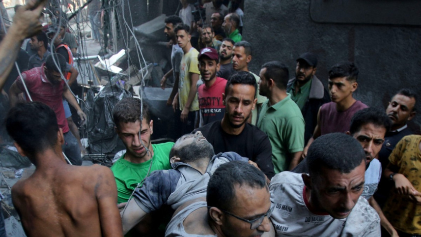 গাজায় ইসরায়েলি বোমাবর্ষণের পর আহত ফিলিস্তিনি ব্যক্তিকে সরিয়ে নিয়ে যাওয়া হচ্ছে। ছবি: এএফপি