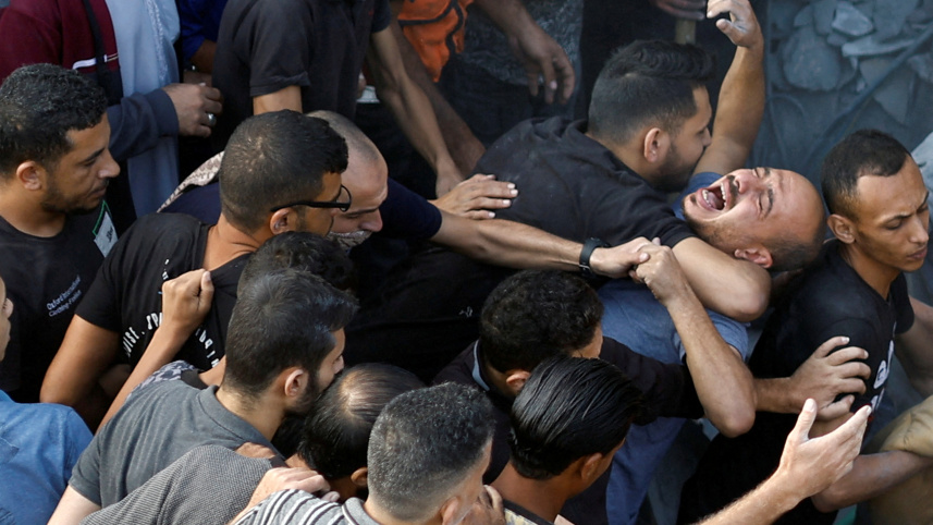 মাঘাজি শরণার্থীশিবিরে বিমানহামলার পর আপনজনদের মরদেহ খুঁজে বের করছেন ফিলিস্তিনিরা। ছবি: রয়টার্স