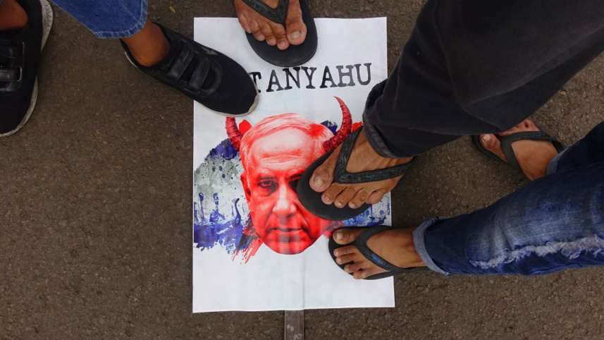 ইন্দোনেশিয়ার রাজধানী জাকার্তার স্মৃতিসৌধের সামনে ইসরায়েলের হামলার বিরুদ্ধে আয়োজিত বিক্ষোভে নেতানিয়াহুর কার্টুন সম্বলিত পোস্টারের ওপর পা রেখে ফিলিস্তিনিদের সঙ্গে একাত্মতা ঘোষণা করছেন দেশটির নাগরিকরা। ছবি: এএফপি