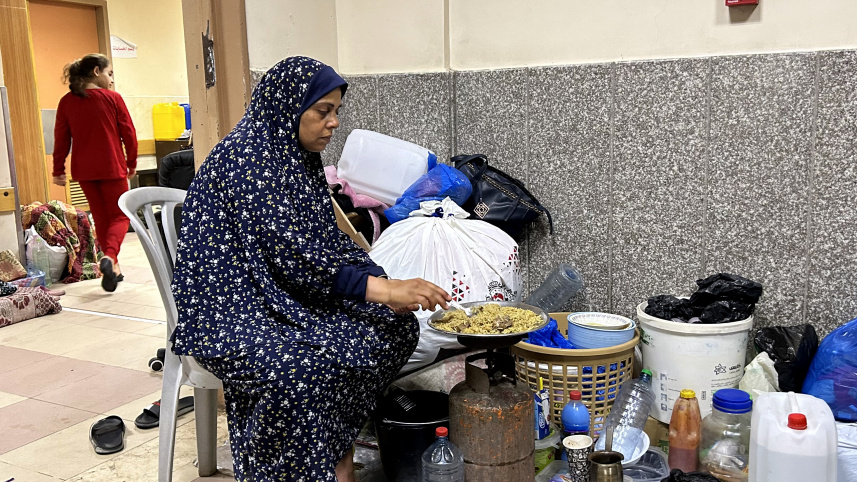 একজন বাস্তুচ্যুত মানুষ হাসপাতালের ভেতর রান্না করার চেষ্টা করছেন। ছবি: এএফপি