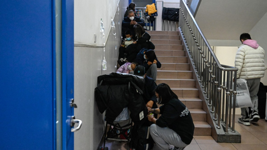 বেইজিং এর এক শিশু হাসপাতালে জায়গার অভাবে সিঁড়িতেই শিশুদের চিকিৎসা দেওয়া হচ্ছে। ছবি: এএফপি (২৩ নভেম্বর, ২০২৩)