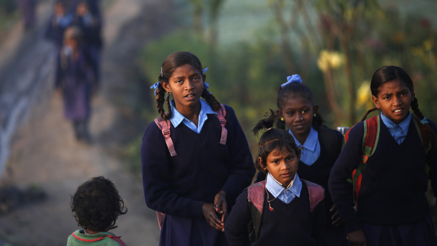 দিল্লিতে শিক্ষার্থীরা মাঠ পেরিয়ে স্কুলে যাচ্ছে। ছবি: রয়টার্স