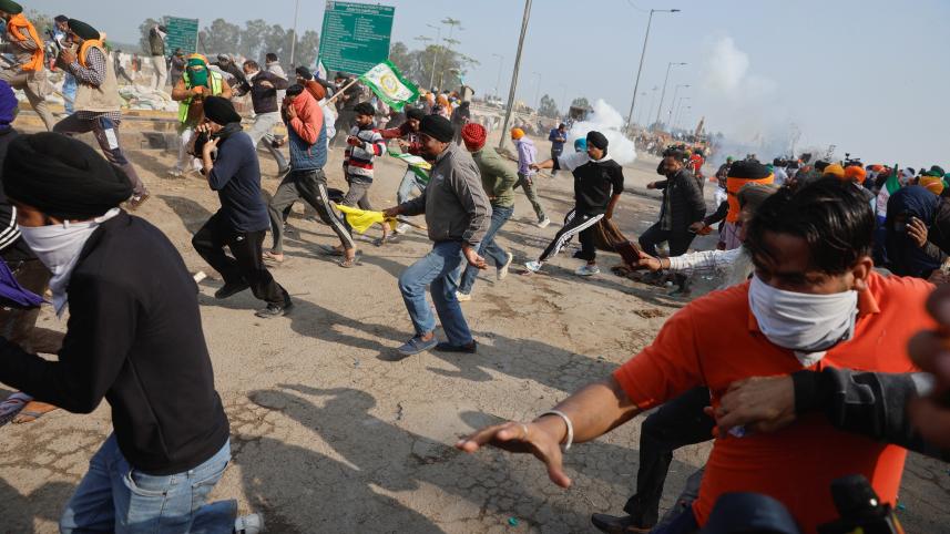 পুলিশের টিয়ারগ্যাস শেল থেকে বাঁচতে পালাচ্ছেন কৃষকরা। ছবি: রয়টার্স