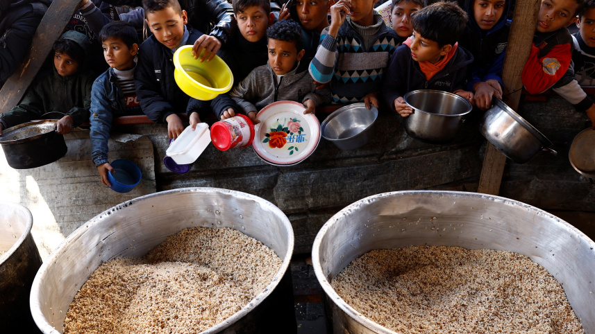 রাফাহর একটি দাতব্য লঙ্গরখানা থেকে খাবার সংগ্রহের জন্য অপেক্ষা করছেন ফিলিস্তিনিরা। ছবি: রয়টার্স