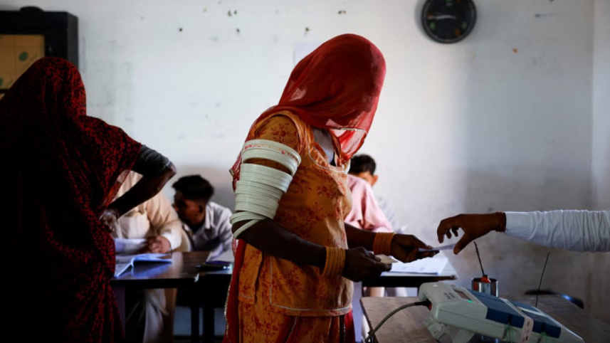 লোকসভা নির্বাচনের দ্বিতীয় পর্যায়ে রাজস্থানের বারমারের এক ভোটকেন্দ্রে ভোট দিচ্ছেন এক নারী। ছবি: রয়টার্স