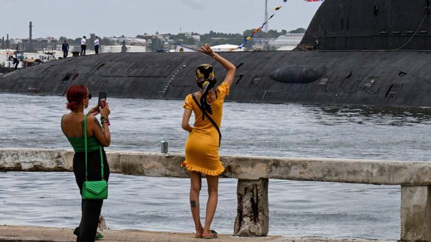 সাবমেরিন ক্রুদের উদ্দেশে হাত নেড়ে অভিবাদন জানাচ্ছেন কিউবান নারী। ছবি: এএফপি