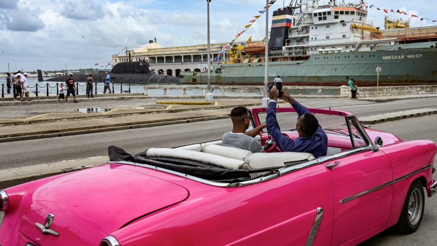 গাড়ি থেকে রুশ সাবমেরিনের ছবি তুলছেন কিউবার নাগরিকরা। ছবি: এএফপি