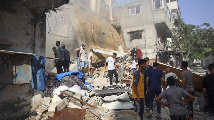 বুরেইজ শরণার্থী শিবিরে ইসরায়েলি হামলার পর আহতদের উদ্ধারের প্রচেষ্টা। ছবি: এএফপি