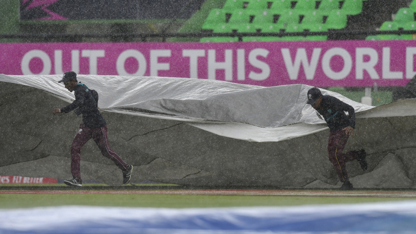 ground_staff_run_on_the_field_with_covers_as_rain_stopped_play.jpg