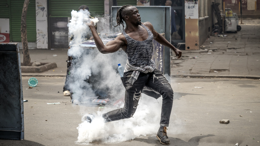 কেনিয়ায় পুলিশের উদ্দেশে টিয়ার গ্যাস শেল ফেরত পাঠাচ্ছেন এক বিক্ষোভকারী। ছবি: এএফপি