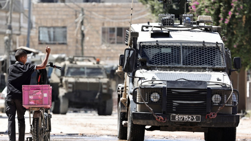 পশ্চিম তীরে অভিযানের সময় পথচারীদের সঙ্গে আলাপ করছে ইসরায়েলি সেনাবাহিনীর সদস্যরা। ছবি: এএফপি