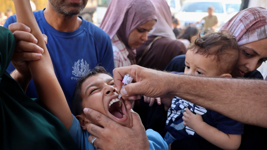 এক ফিলিস্তিনি শিশুকে টিকা দিচ্ছেন স্বাস্থ্যকর্মী। ছবি: এএফপি