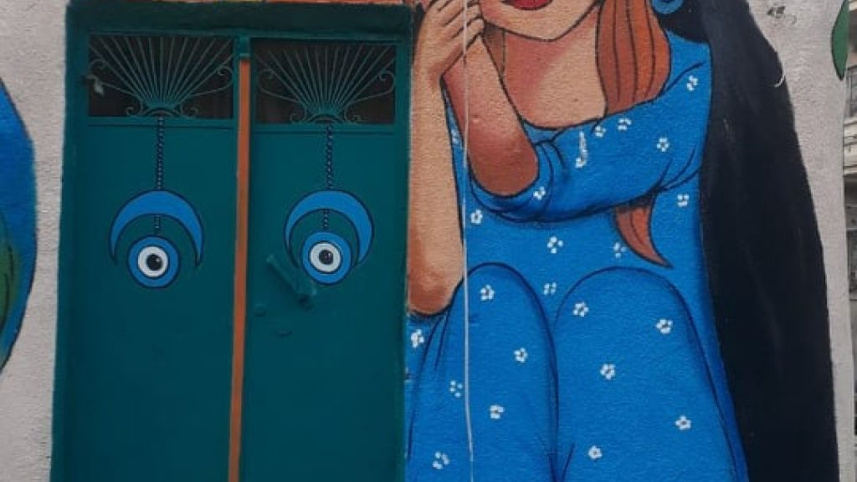 বাগদাদেদ দেওয়ালে আলি খলিফা  ও বাটারফ্লাই এফেক্টের আঁকা ম্যুরাল। ছবি: সংগৃহীত