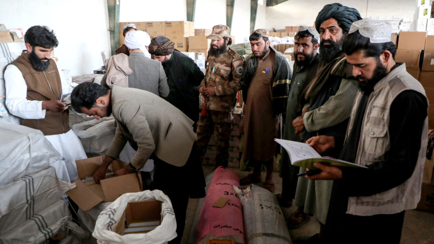 ইরান থেকে আসা বই পরীক্ষা করছেন তালেবান কর্মকর্তারা। ছবি: এএফপি