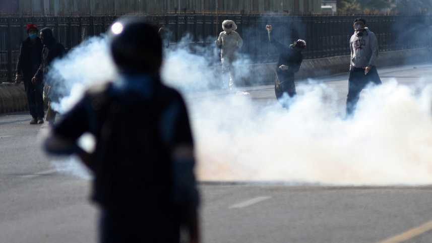 নিরাপত্তা কর্মীদের দিকে ঢিল ছুঁড়ছেন বিক্ষোভকারীরা। ছবি: রয়টার্স