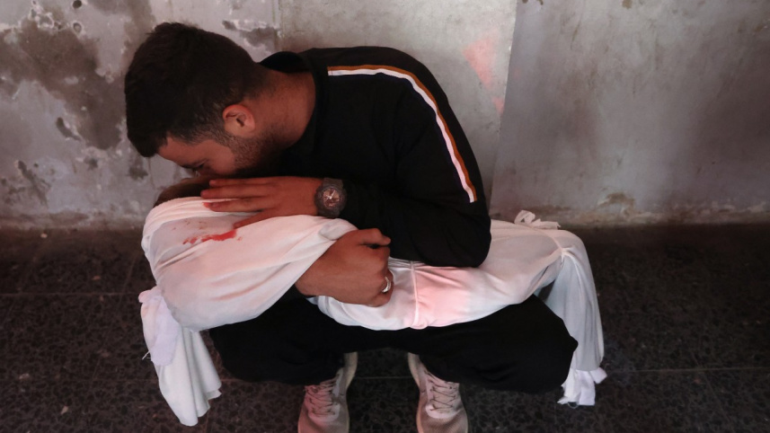 গাজায় মরদেহ আঁকড়ে ধরে শোক প্রকাশ করছেন এক ফিলিস্তিনি। ছবি: এএফপি