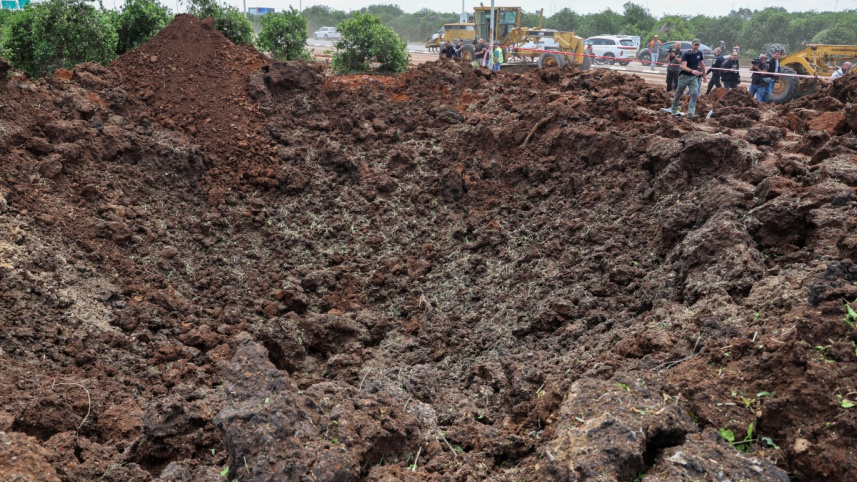 বেন গুরিয়ন বিমানবন্দরের টার্মিনাল তিনের পার্কিং লটের কাছে ক্ষেপণাস্ত্রের আঘাতে বড় গর্ত তৈরি হয়। ছবি: এএফপি 