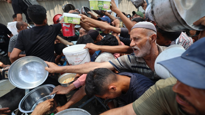 নুসেইরাত শিবিরে খাবারের জন্য ফিলিস্তিনিদের অপেক্ষা। ছবি: এএফপি