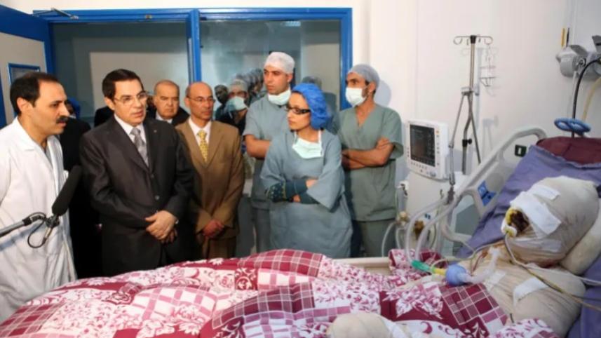 তিউনিসিয়ার সাবেক স্বৈরশাসক জয়নাল আবেদিন বেন আলি হাসপাতালে মোহাম্মদ বোয়াজিজিকে দেখতে যান। সরকারি কর্মকর্তাদের লাঞ্ছনার যন্ত্রণা সহ্য করতে না পেরে নিজের গায়ে আগুন দেন বোয়াজিজি। ফাইল ছবি: রয়টার্স (২৮ ডিসেম্বর, ২০১০) 