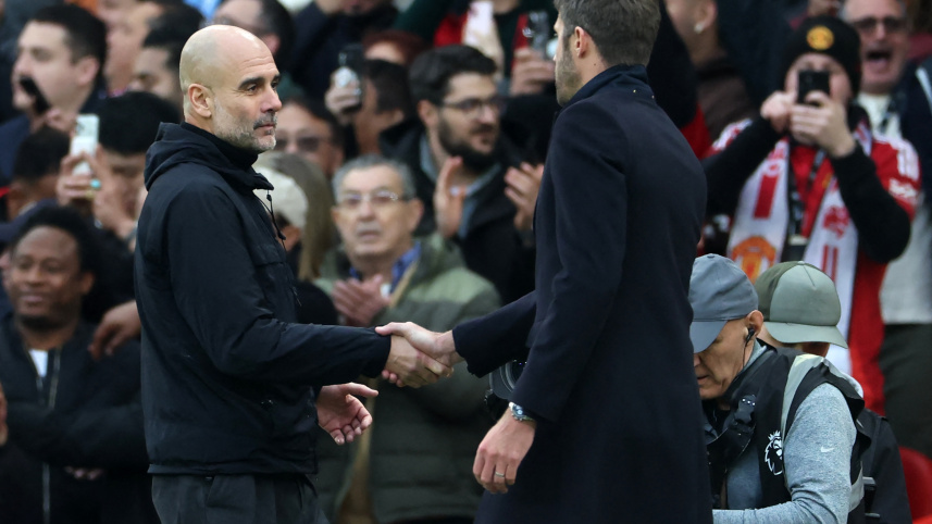 Manchester City's Spanish manager Pep Guardiola (L) shakes hands with Manchester United's English Interim head coach Michael Carrick (R)
