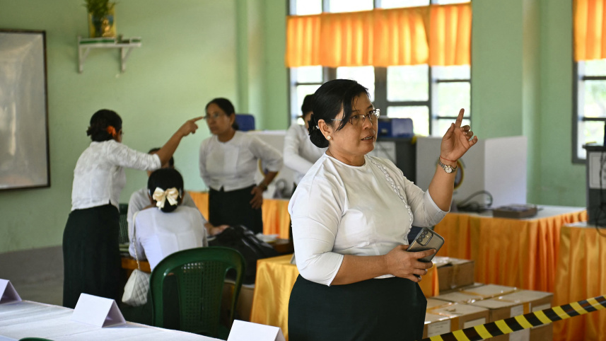 ভোটকেন্দ্রে কাজ করছেন নির্বাচন কমিশনের স্বেচ্ছাসেবকরা। ছবি: এএফপি