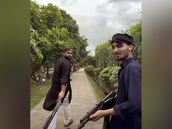 খেলনা বন্দুক হাতে লিমন তোহা ও স্বপন মোল্লা। ছবি: ভিডিও থেকে নেওয়া