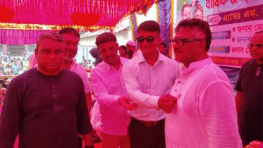 রুহুল কুদ্দুস তালুকদার দুলুকে ধানের শীষের স্বর্ণের কোট-পিন পরিয়ে দেন ইউএনও মো. আল এমরান খাঁন। ছবি: স্টার 