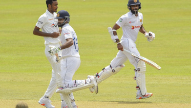 Sri Lanka's Dimuth Karunaratne (C) and Lahiru Thirimanne take a run (1).jpg