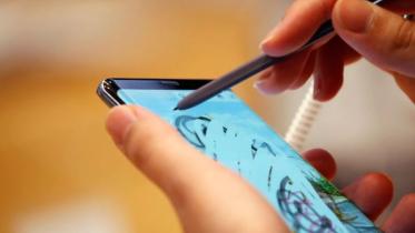 একজন সম্ভাব্য ক্রেতা দোকানে স্যামসাং গ্যালাক্সি ফোন যাচাই করছেন।