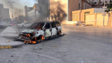 শনিবারের সংঘর্ষে ত্রিপোলির সড়কে গাড়িতে আগুন জ্বলছে। ছবি: রয়টার্স