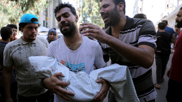 ইসরায়েলি বিমানহামলায় নিহত ফিলিস্তিনি শিশুর মরদেহ হাতে শোকাহত পরিবারের সদস্যরা। ছবি: এএফপি