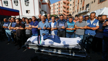 ফিলিস্তিনি সাংবাদিক মোহাম্মেদ আবু হাত্তাবের জানাজায় অংশ নিছেন তার সহকর্মী, আত্মীয়-পরিজন ও বন্ধুবান্ধব। দক্ষিণ গাজা উপত্যকায় পেশাগত দায়িত্ব পালনের সময় ইসরায়েলের বোমাবর্ষণে নিহত হন তিনি। ছবি: রয়টার্স