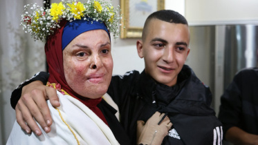 ফিলিস্তিনি নাগরিক ইসরা জাবিস (৩৭) মুক্তি পেয়ে পরিবারের কাছে ফিরেছেন। ছবি: এএফপি