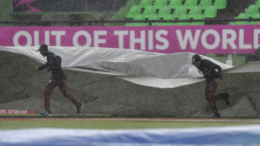 ground_staff_run_on_the_field_with_covers_as_rain_stopped_play.jpg