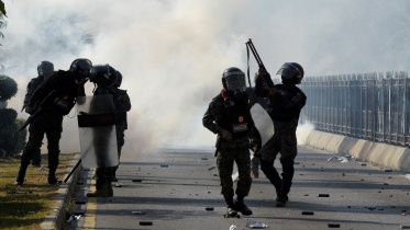 ইসলামাবাদে বিক্ষোভকারীদের ছত্রভঙ্গ করতে টিয়ার গ্যাস শেল ছুঁড়ছে নিরাপত্তা বাহিনীর সদস্য। ছবি: রয়টার্স