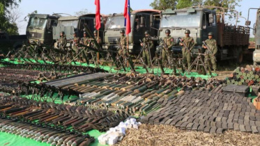 মিয়ানমারের সামরিক জান্তার কাছ থেকে ছিনিয়ে নেওয়া অস্ত্র, গোলাবারুদ, সামরিক ট্রাক ও অন্যান্য উপকরণসহ ছবি তুলছেন আরাকান আর্মির সদস্যরা। ফাইল ছবি: এএফপি