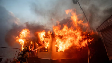 লস অ্যাঞ্জেলেসে দাবানল নিয়ন্ত্রণে আনার চেষ্টা করছেন এক দমকলকর্মী। ছবি: রয়টার্স