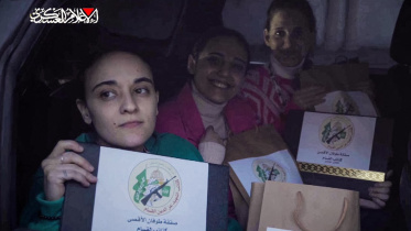 উপহারের ব্যাগ ও সনদ হাতে ছবির জন্য পোজ দিচ্ছেন তিন ইসরায়েলি জিম্মি। ছবি: এএফপি