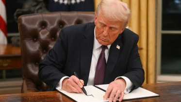 গভীর মনোযোগে নির্বাহী আদেশে সাক্ষর করছেন ট্রাম্প। ছবি: এএফপি