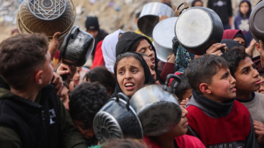 গাজার বেইত লাহিয়া এলাকায় একটি দাতব্য লঙ্গরখানা থেকে ইফতারের জন্য খাবার সংগ্রহ করতে ফিলিস্তিনি শিশুরা অপেক্ষা করছে। ছবি: এএফপি