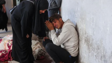 গাজা সিটিতে ইসরায়েলি হামলায় নিহত এক ব্যক্তির মরদেহের সামনে শোক করছেন তার পরিবারের সদস্যরা। ছবি: এএফপি