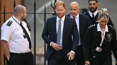 নিরাপত্তাকর্মী পরিবেষ্টিত অবস্থায় আদালতে প্রবেশ করছেন প্রিন্স হ্যারি। ছবি: এএফপি