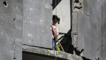 জাবালিয়ায় ইসরায়েলি হামলার পর ধ্বংসস্তুপ পরিষ্কারের কাজে সহায়তা করছে এক ফিলিস্তিনি শিশু। ছবি: এএফপি