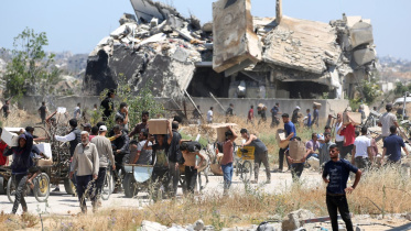 জিএইচএফের ত্রাণকেন্দ্র থেকে ত্রাণ নিয়ে বাড়ি ফিরছেন ফিলিস্তিনিরা। ছবি: এএফপি